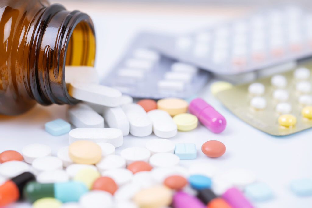 Medication blister packs and pill bottle on table representing medication assistance support in Sydney